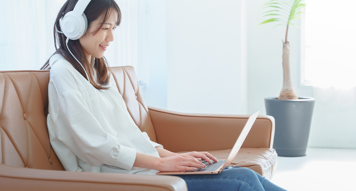 ソファーでパソコンをしている人の写真